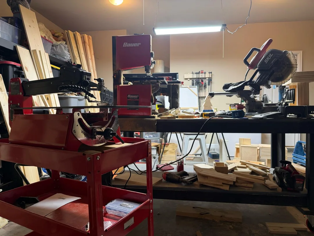Steven's Sharpsburg woodworking workshop with saws, lumber, and hand tools